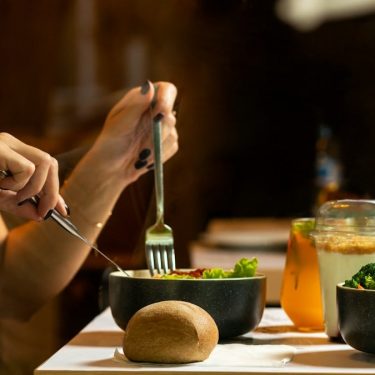 Women eating tasty chicken salad with dessert